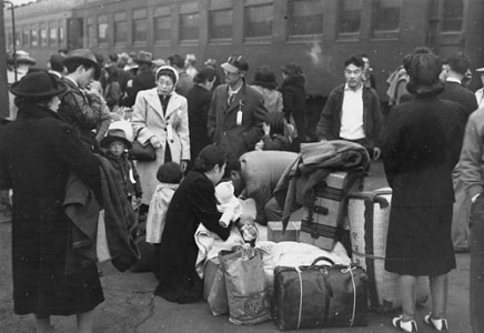 Japanese Americans near trains during Relocation.