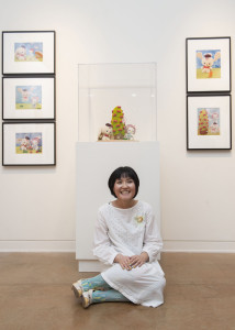 Eimi Takano sits in front of her plush sculpture, Ribbon Camp.