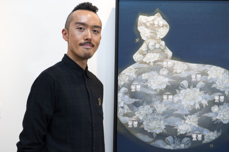 Martin Hsu stands next to his painting Hello Kitty Transcendence, on view now as part of Hello! Exploring the Supercute World of Hello Kitty at JANM.