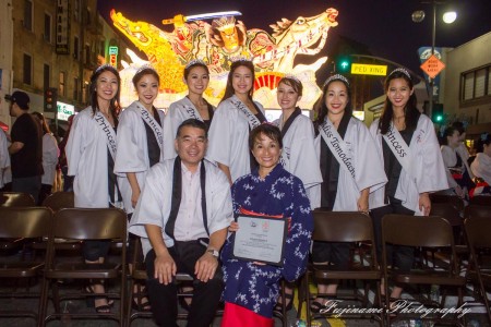 The 2015 Nisei Week Court, with 2015 Nisei Week Foundation President Terry Hara and a community member, poses in front of the 2015 Nebuta float, designed especially for this year's parade by master Nebuta float artist Hiroo Takenami. Photo by John Fujinami.